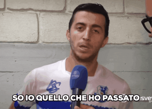 a man holding a microphone with the words so io quello che ho passato