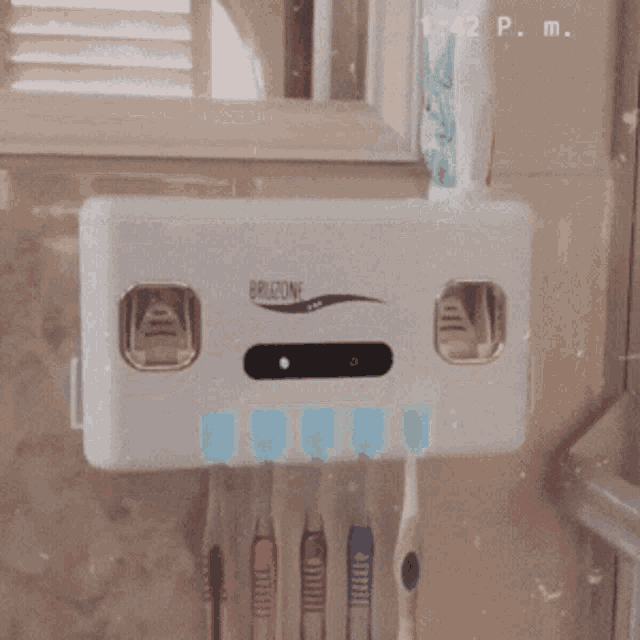 a toothbrush holder with a toothpaste dispenser attached to it