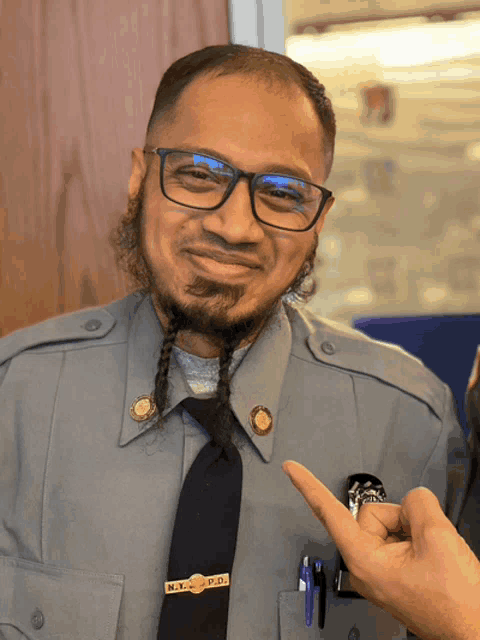 a man wearing glasses and a badge that says m.i.c.p.d.