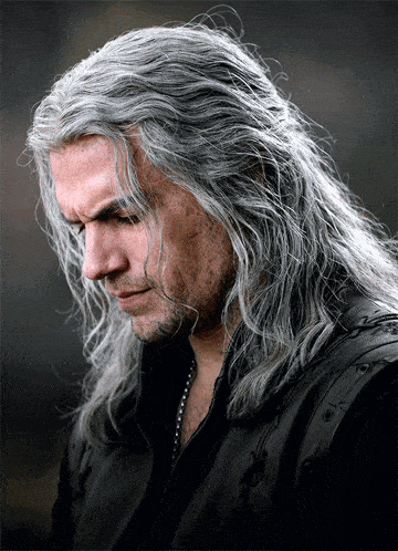 a man with long grey hair is wearing a black leather jacket