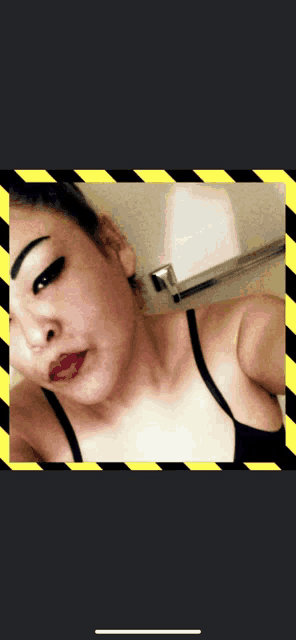 a woman taking a selfie with a yellow and black border around her