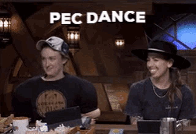 a man and a woman are sitting at a table with the words pec dance behind them .