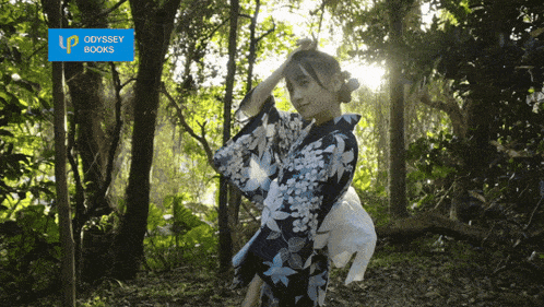 a woman in a kimono stands in a forest with an odyssey books sign above her