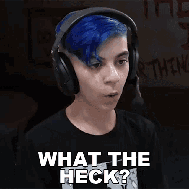 a young man with blue hair is wearing headphones and saying what the heck ?