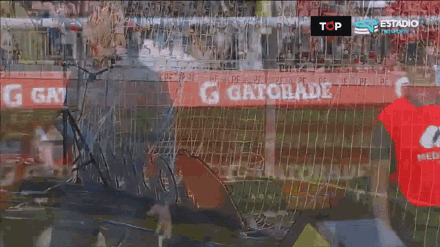 a man in a blue shirt stands in front of a gatorade banner