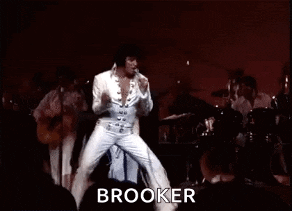 elvis presley is dancing on stage in front of a crowd while playing a guitar .