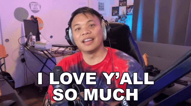 a man wearing headphones is sitting in front of a microphone and saying i love y'all so much