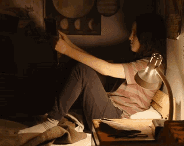 a person sitting on a bed looking at a phone