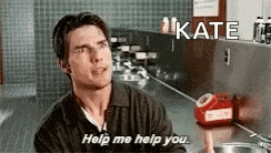 a man is talking to a woman in a kitchen while holding a red telephone .