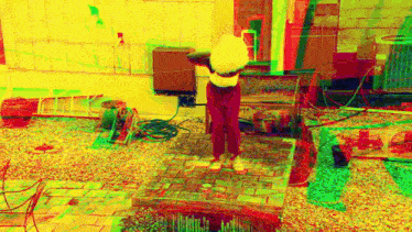 a person is standing on a brick platform in a yard with a hose .