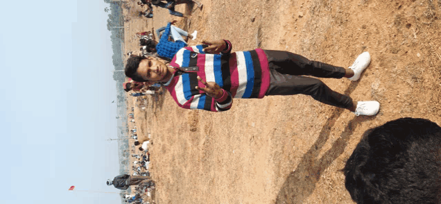 a man in a striped shirt stands in a field