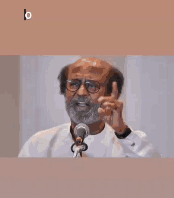 a man speaking into a microphone with the words " only rajnikanth can exit politics without e " below him