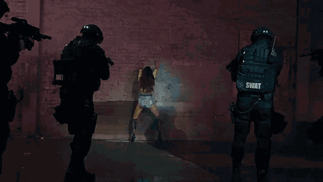 a swat officer stands in front of a woman