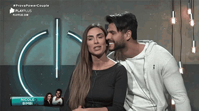 a man kisses a woman on the cheek in front of a sign that says provapowercouple