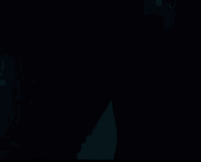 a close up of a woman 's face in a dark room with her eyes closed