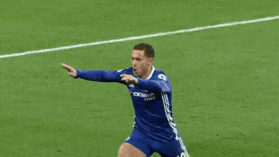 a soccer player wearing a blue jersey that says yokohama tyres is celebrating on the field .