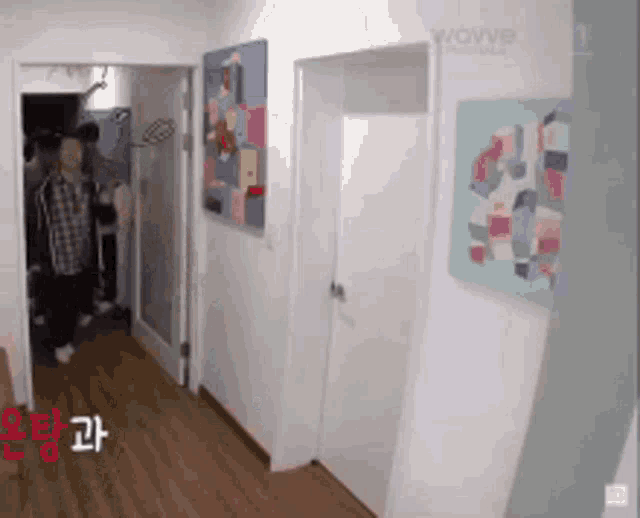 a hallway with paintings on the wall and the word wavve on the bottom