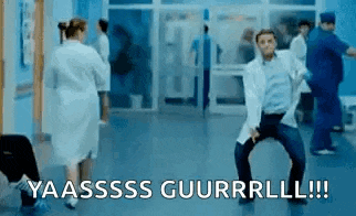 a man in a lab coat is dancing in a hospital hallway while a nurse stands behind him .