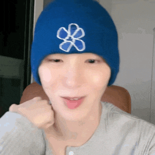 a person wearing a blue beanie with a flower on it .