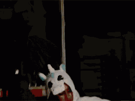a person in a unicorn costume is standing in front of a computer monitor