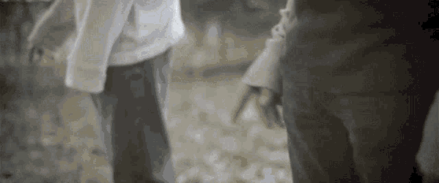 a man and a woman are standing next to each other holding hands