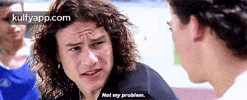 a man with long curly hair is talking to another man and says `` not my problem '' .