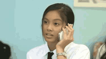 a girl is talking on a cell phone in a classroom .