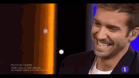 a man is smiling in front of a sign that has the number 1 on it