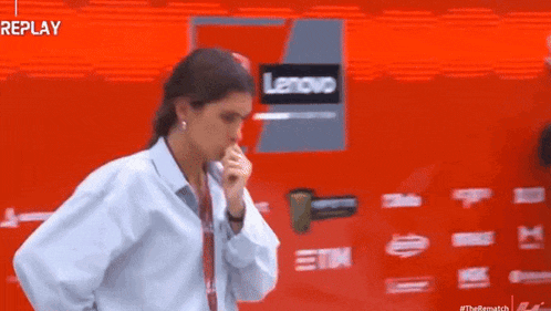 a woman is coughing in front of a red lenovo truck .