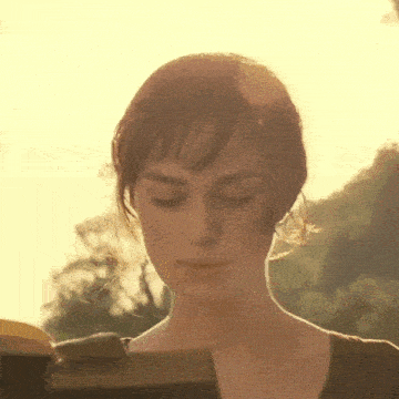 a woman is reading a book with her eyes closed .