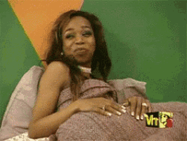 a woman laying on a bed with a vh1 logo on the wall