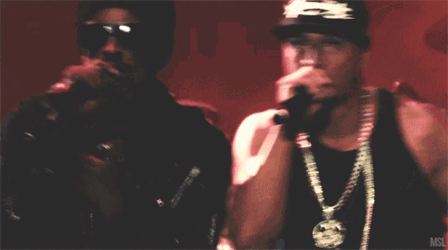 a man singing into a microphone while wearing a hat that says snoop dogg on it