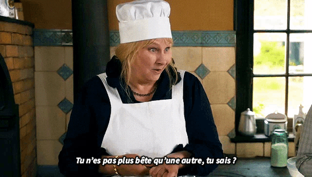 a woman wearing a chef 's hat and apron says " tu n'es pas plus bete qu'une autre "