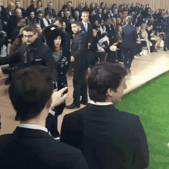 a man taking a picture of a woman walking down the runway