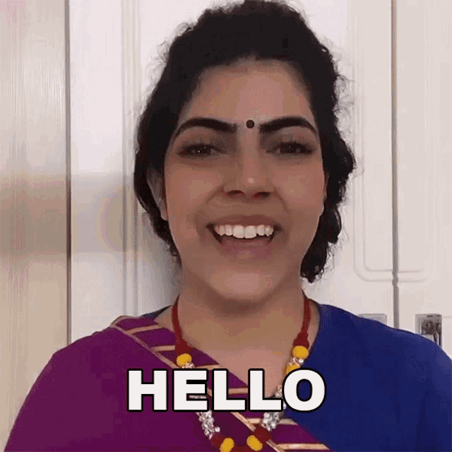 a woman wearing a purple and blue dress is smiling and says hello