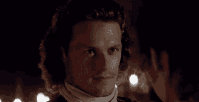 a man with curly hair is looking at a woman