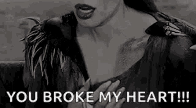 a woman is holding her chest with the words `` you broke my heart '' written on it .