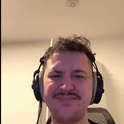 a man with a mustache wearing headphones makes a funny face