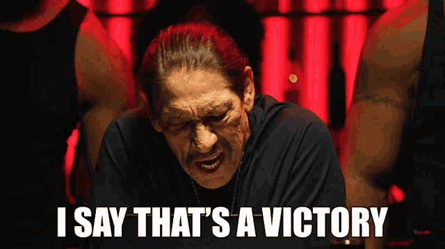 a man says " i say that 's a victory " in front of a red background
