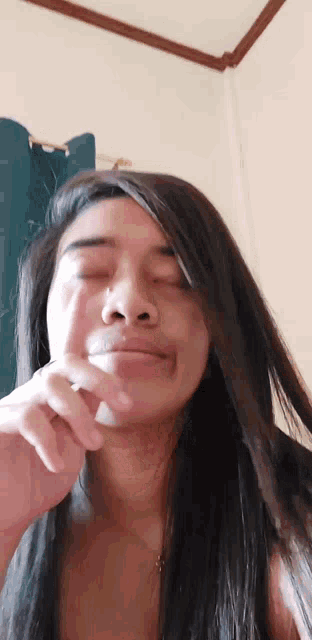 a woman with her eyes closed and her hand on her chin