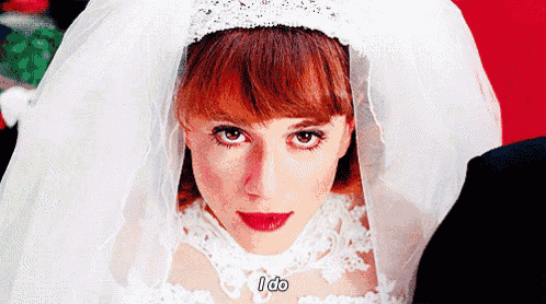 a woman in a wedding dress and veil is saying i do
