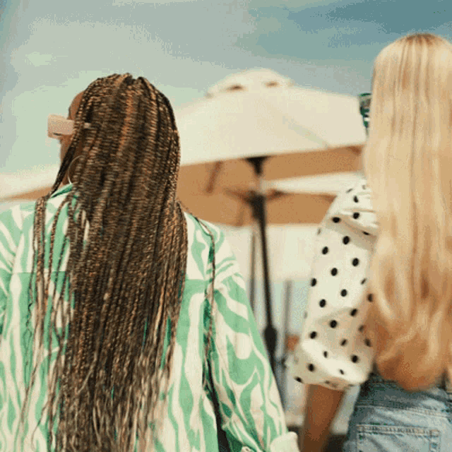 a woman in a zebra print shirt is walking with another woman in a polka dot shirt