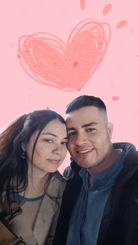a man and a woman are posing for a picture with a heart drawn on the background