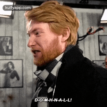 a man with a beard is wearing a suit and tie and is talking .