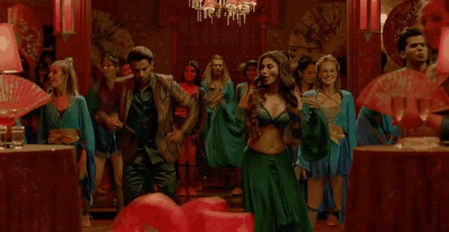 a woman in a green dress is dancing with a man in a suit