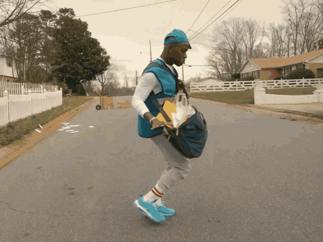 a man in a blue vest is walking down a street with a bag on his back