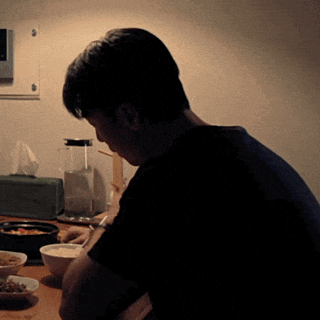 a man is sitting at a table with bowls of food