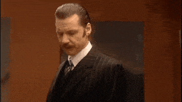 a man in a suit and tie says that he is the greatest man in the world