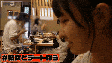 a woman sitting at a table with a sign that says #