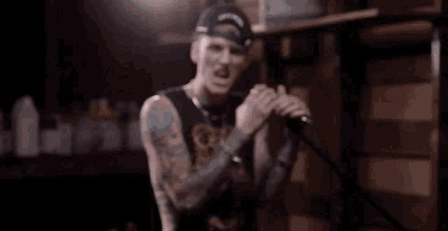 a man singing into a microphone wearing a hat that says ' bay area ' on it
